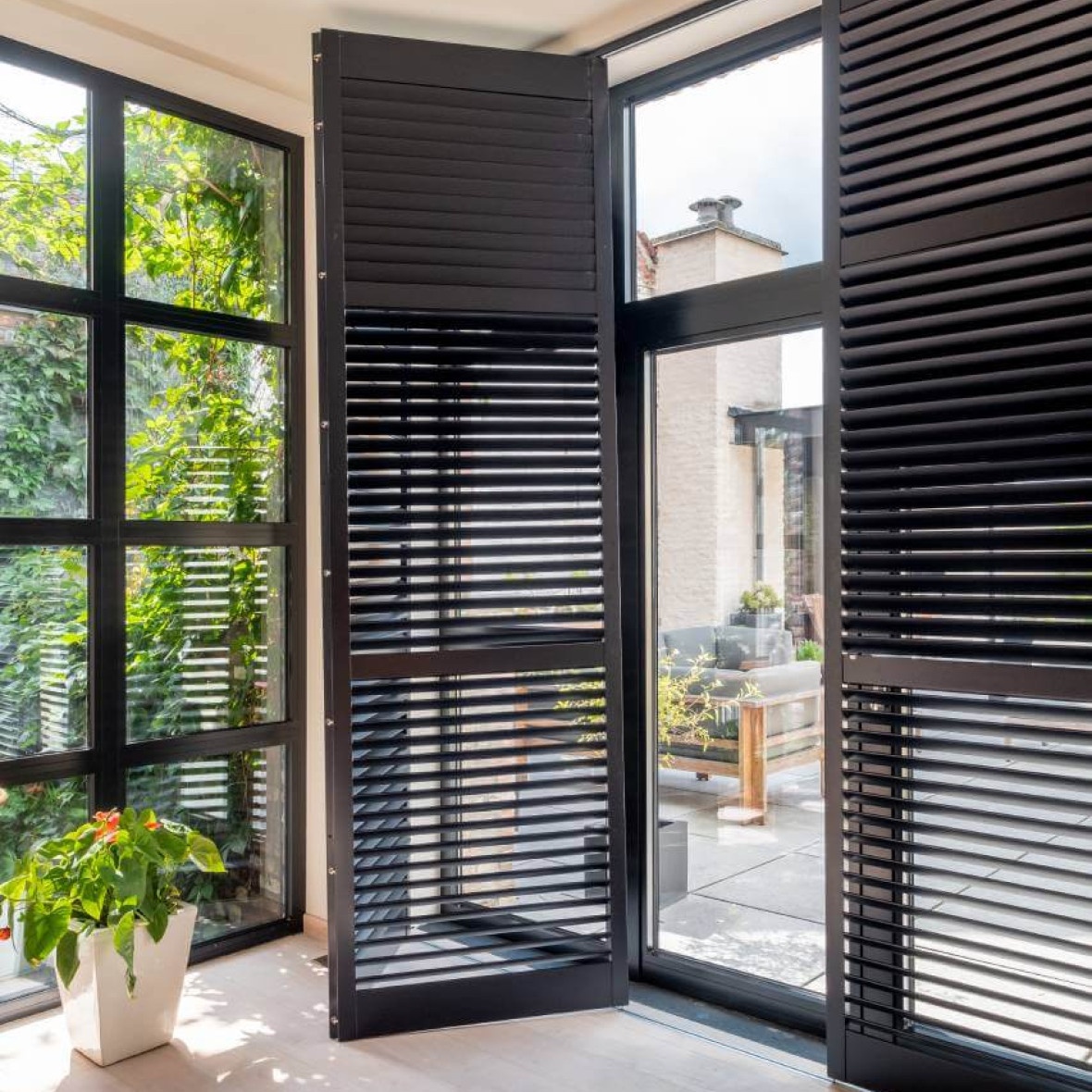 Zwarte houten shutters op rail, geopend